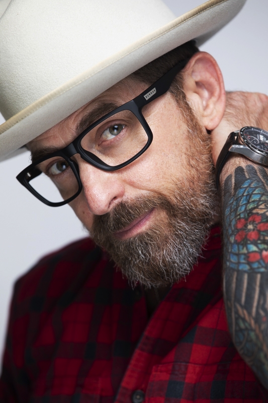 Tattooed man with hat and glasses