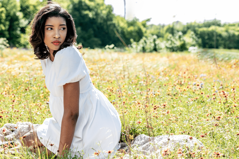 Beautiful black senior portrait girl in field of wild flowers round rock Texas