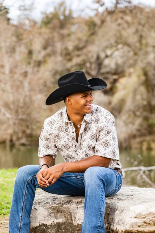 young black man senior picture in texas with black cowboy hat