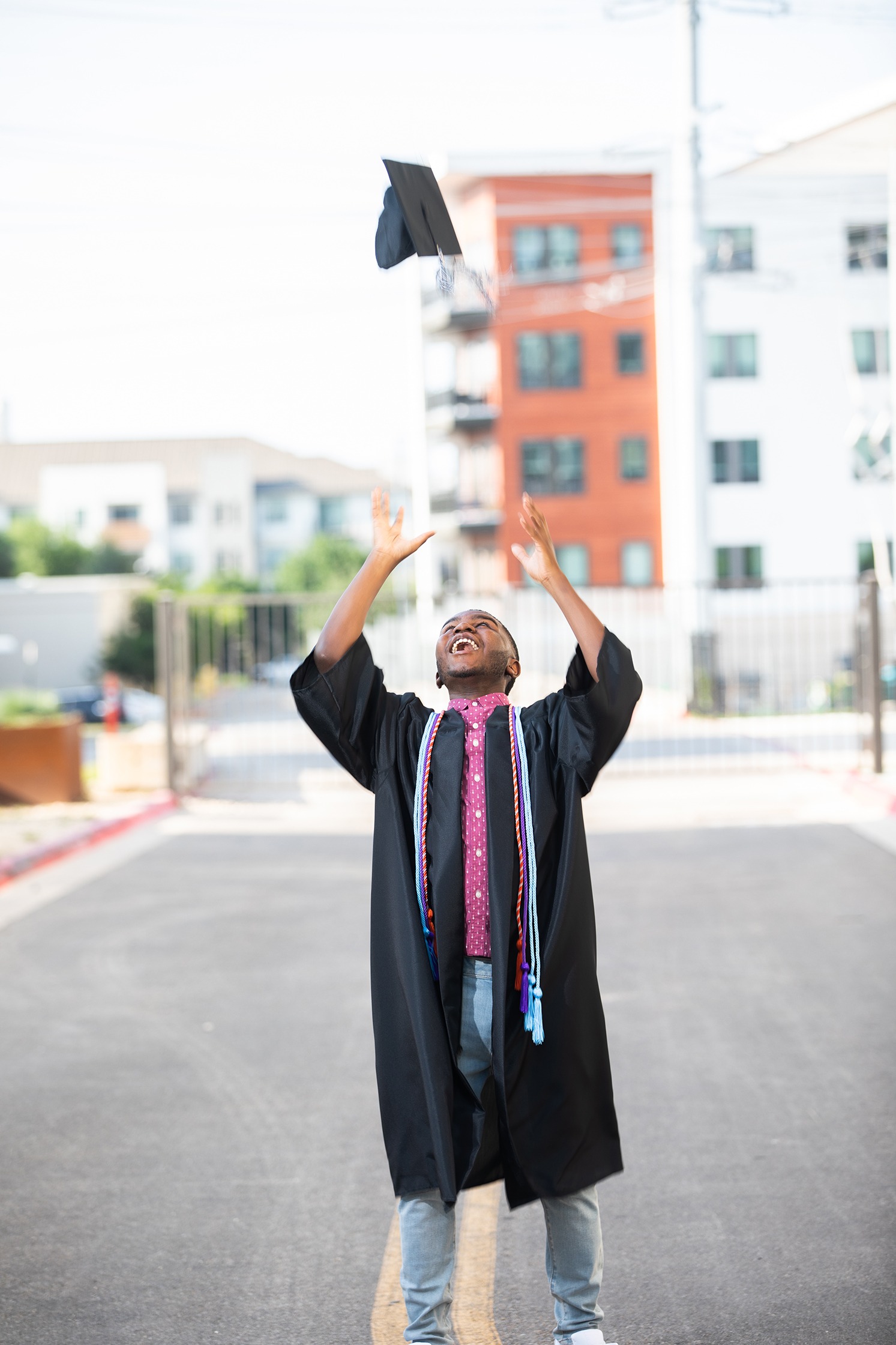 high school senior graduate throws cap in the air