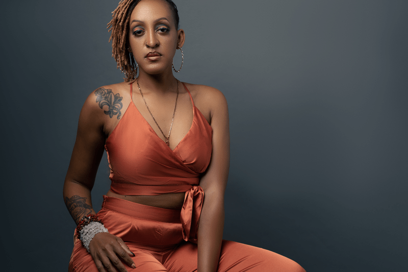 beautiful black woman with blonde dreadlocks in orange outfit