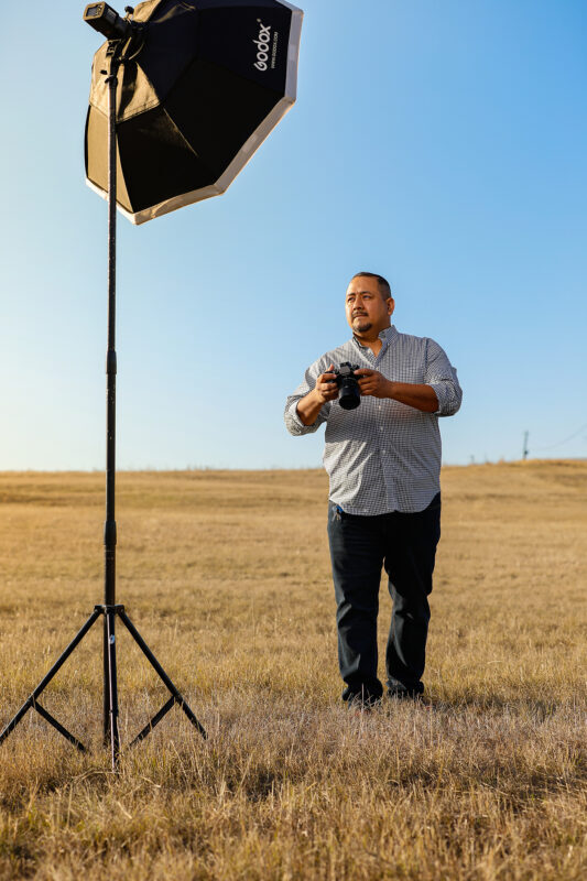 Manor Photographer branding portrait, Alex in a field with Godox light