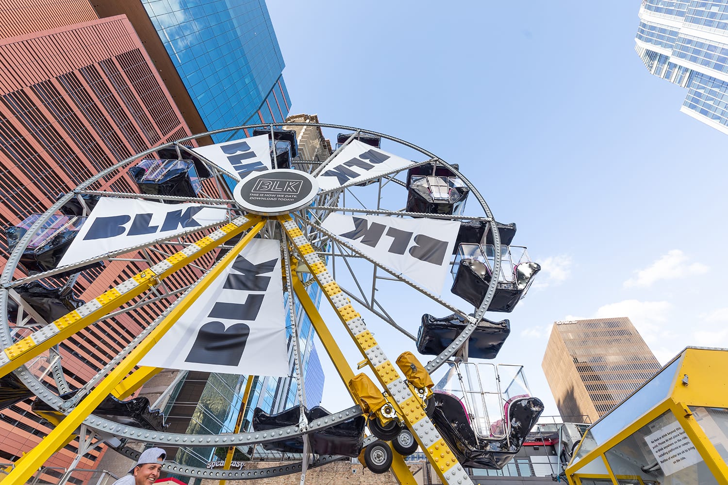 Branded Ferris wheel at an outdoor SXSW event with downtown Austin buildings in the background