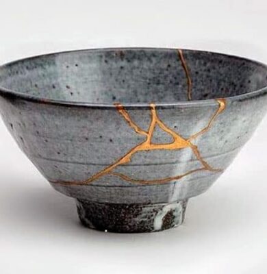 Gray ceramic bowl repaired in the Japanese kintsugi style with visible gold seams