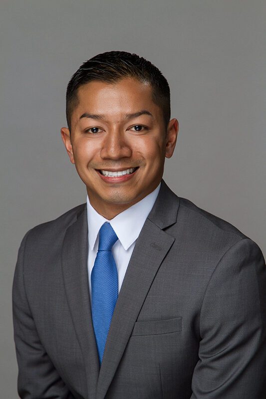 business headshot man in gray suit on gray background