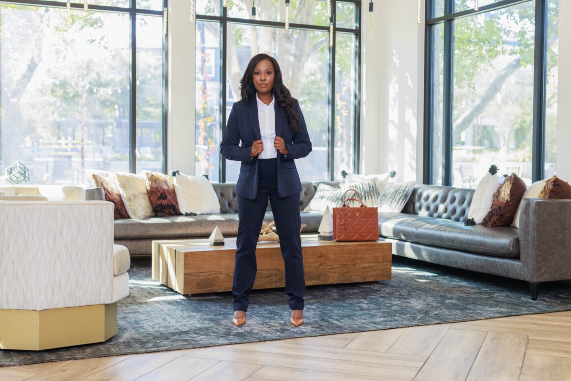 Attorney in a navy suit standing for a full-length portrait in a stylish office lounge